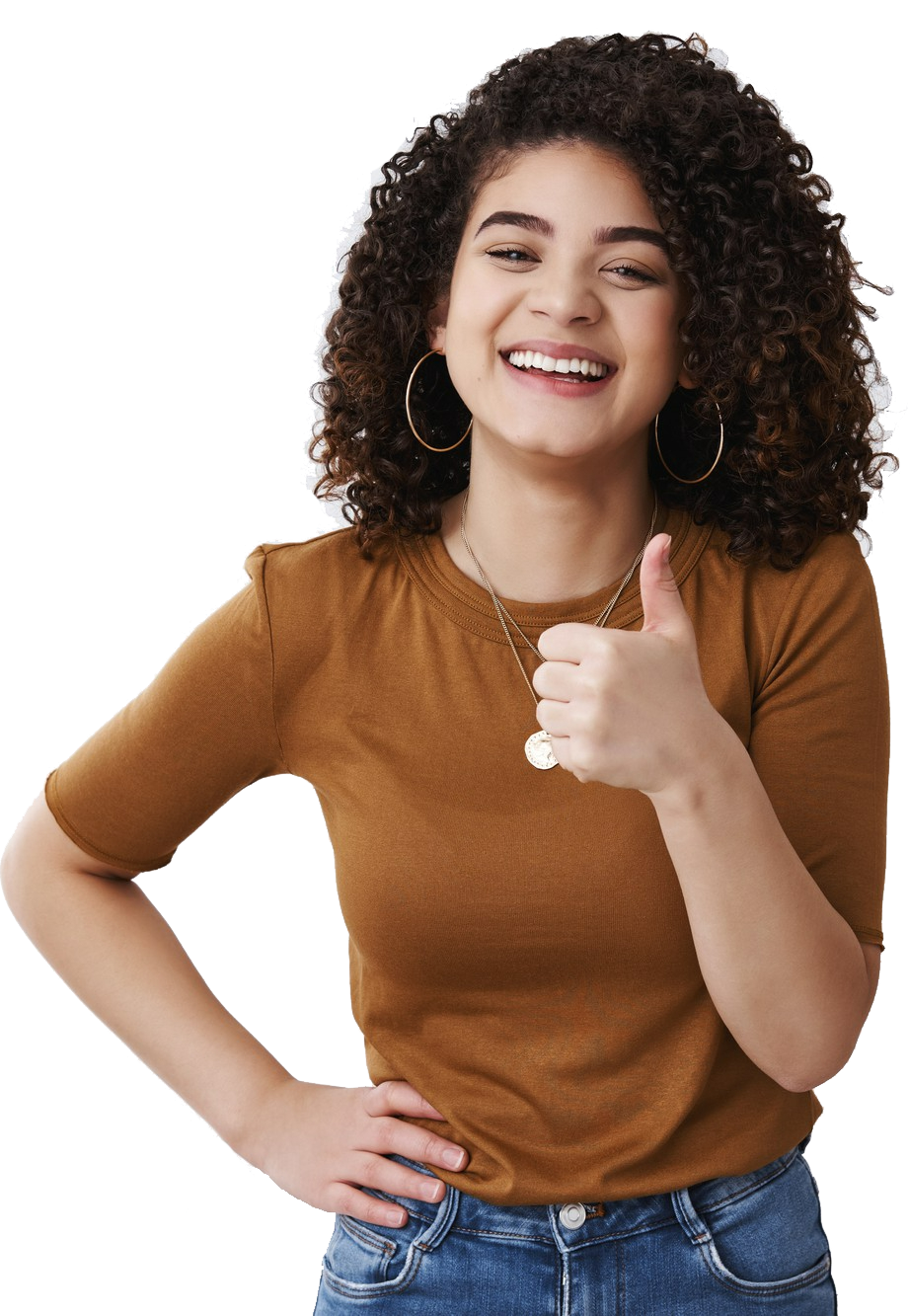 Nesta imagem vemos uma jovem mulher negra, vestindo uma calça jeans e uma blusa marrom. Ela está sorrindo e fazendo um sinal de "jóia" com a mão esquerda.